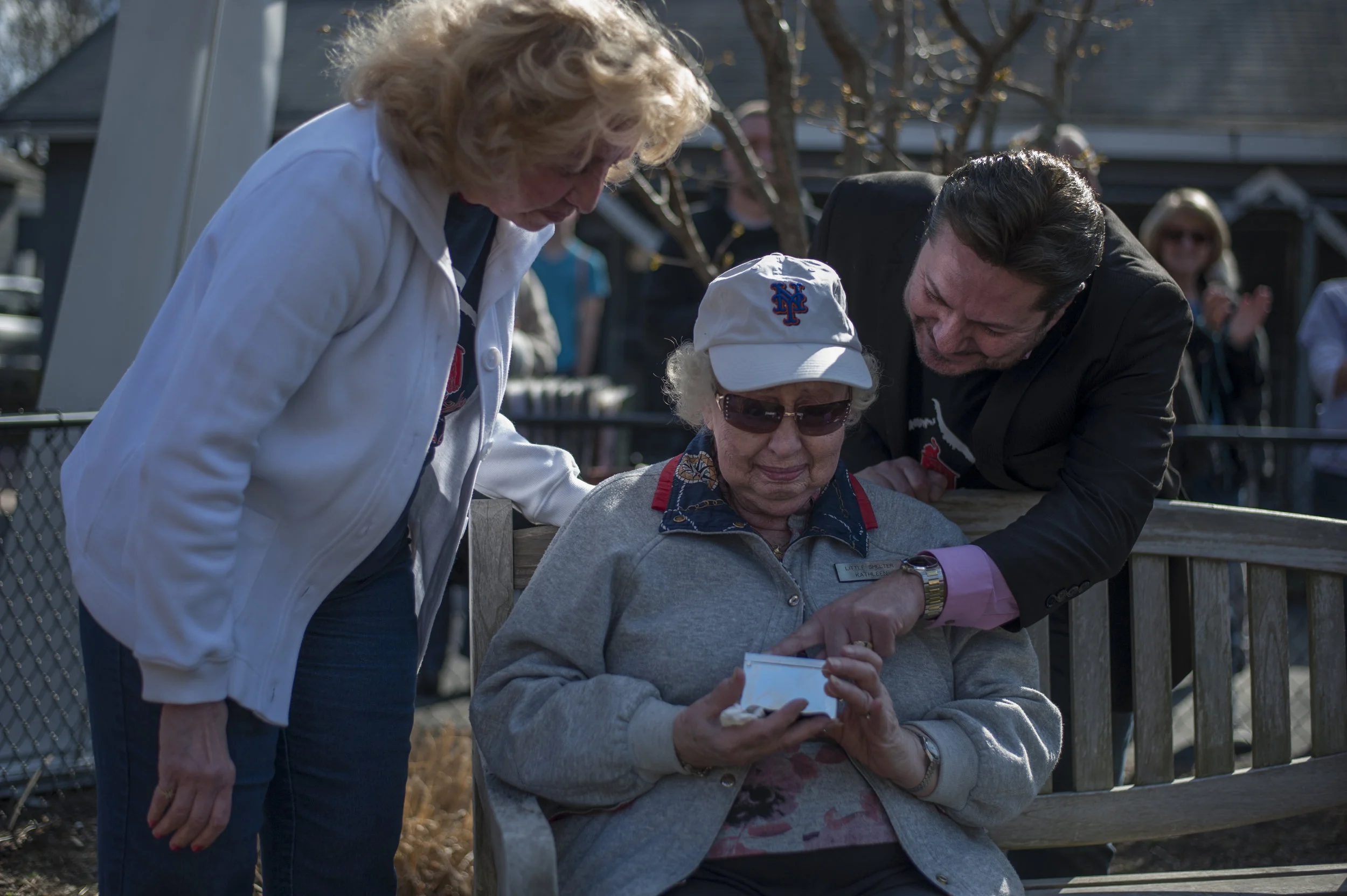   Long Islander News photos/David Weber  Kathleen Eastwood, seated, holds back tears as Little Shelter Director David Ceely, right, and Little Shelter President Maryann Chernovsky, left, present her with a token of gratitude for her 25 years of servi