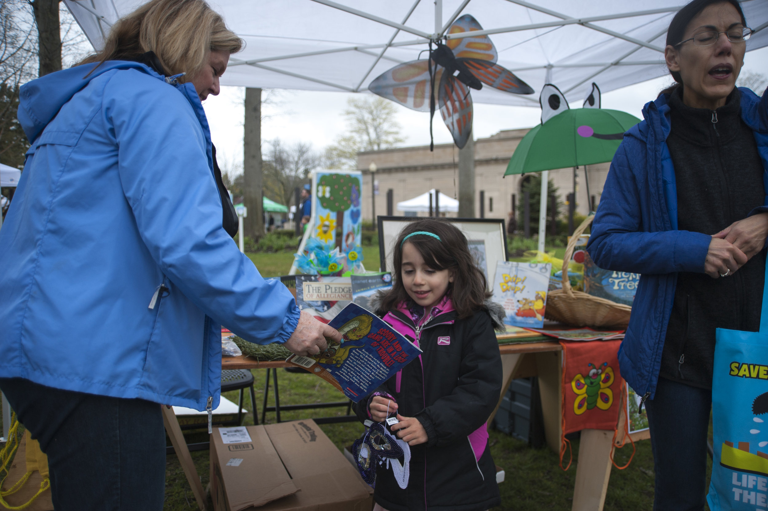  Lori Grube, left, gives a repurposed Scooby Doo book and a butterfly mask to an excited Sophia Amorde, right. 