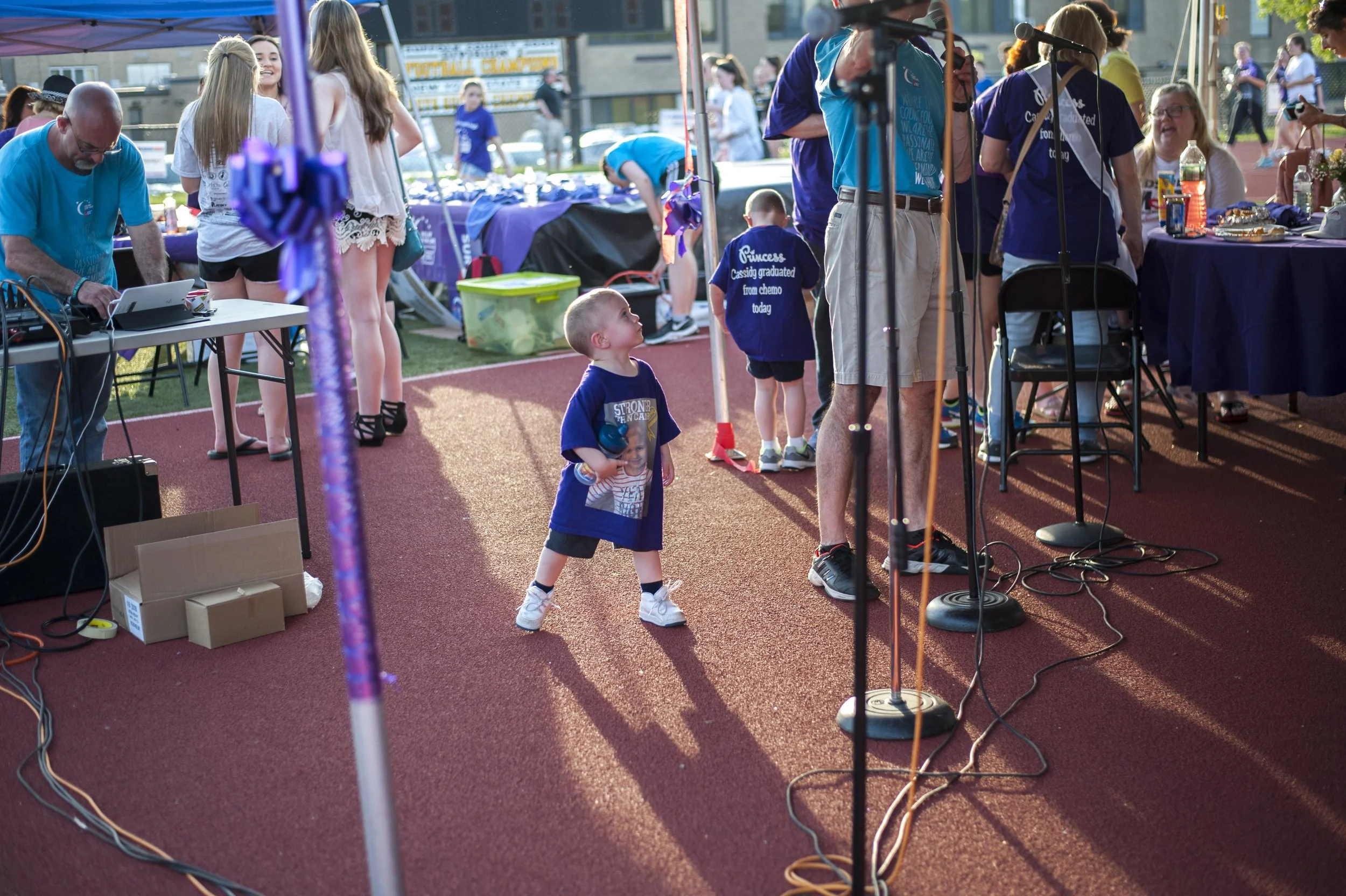  As families under the Survivor’s Tent enjoy a catered meal, a young boy from team ‘Stronger Than Cancer’ dances to music from the DJ behind him.    