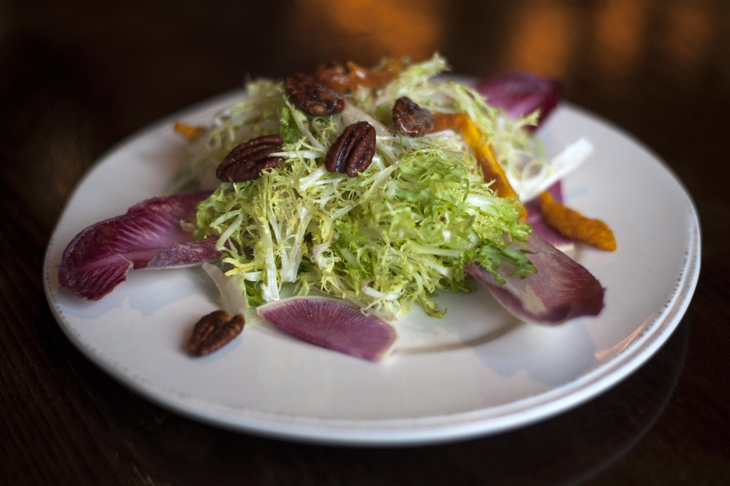  The Organic Bistro Salad features frisee, endive, watermelon radish, candied pecans, dried peaches and topped with sherry citrus dressing. 
