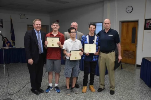  Photos/Northport-East Northport School District  Board president Andrew Rapiejko, far left, and Superintendent Robert Banzer, third from right, recognize the Northport unified basketball team, including Chris Hall, Justin Flood, Justin McCoy and co