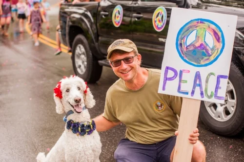  A man poses with his decorated canine companion with marchers advocating for peace in the parade on Eatons Neck. 