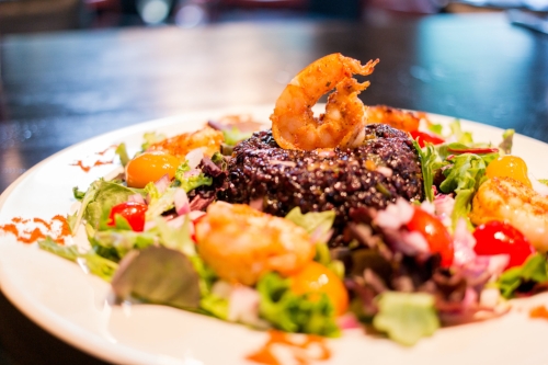  The Drunken Shrimp and Black Voodoo Rice Salad tosses up grilled, mildly-heated Gulf shrimp soaked in cucumber with black voodoo rice in a Thai sesame dressing, with a side of mixed greens.    