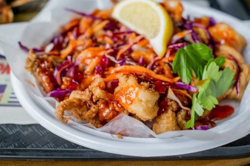  For an Eastern spin on a fried classic, the Kung Pao Calamari generous drizzles sweet chili sauce and slices of carrots and red cabbage over hearty cuts of squid 