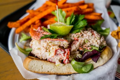  A flagship item, the Homemade Lobster Roll is served as an open sandwich on a warm, locally-sourced brioche roll with crunchy sweet potato fries. 