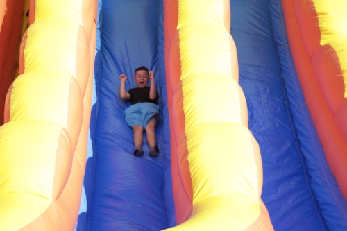  A child slides down a giant inflatable slide.    