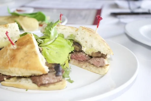  Steak Focaccia ($14) is served with balsamic marinated sliced steak, portabella mushrooms, sliced brie on focaccia bread, with chips.&nbsp; 