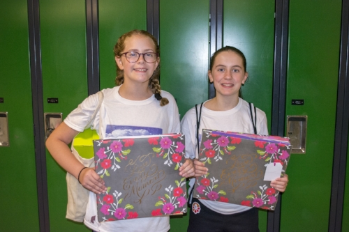  Maddie Woodward and Kate Lysaght, both 11 years old, display scrapbooks they created in Karin Fey’s “Crop Paper Scissors” class. 