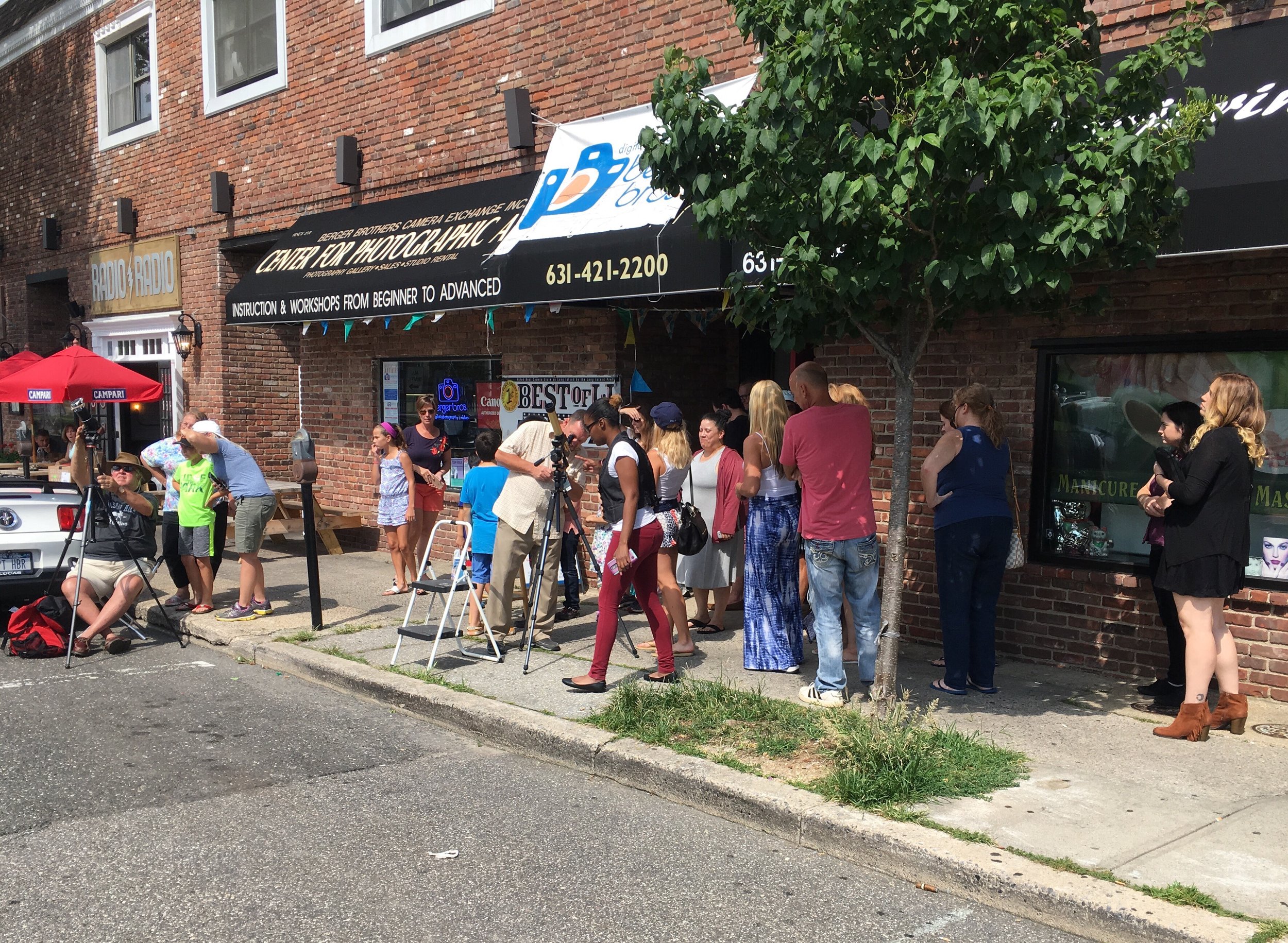  Local residents used telescopes set up outside Berger Bros to get a better view of today's solar eclipse.    Long Islander News photo/Paul Shapiro  