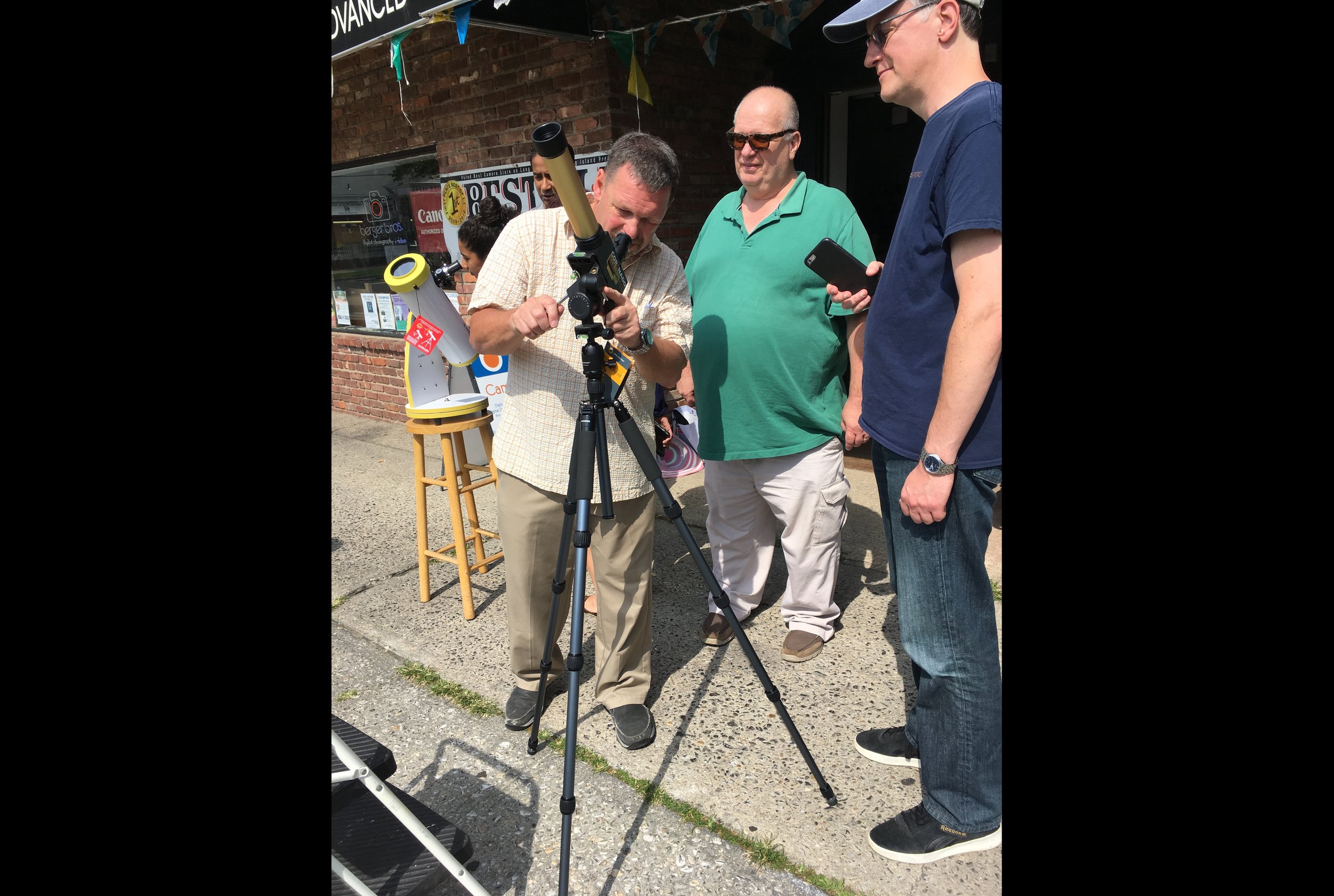  Berger Bros employee Frank Rende adjusts the telescope.  Long Islander News photo/Paul Shapiro  