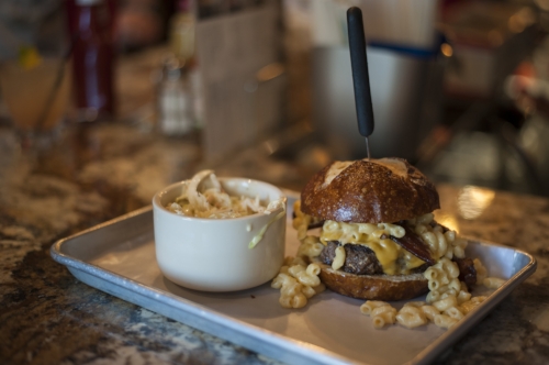  The Mac Attack burger topped with bacon and succulent mac and cheese between a warm pretzel bun. 