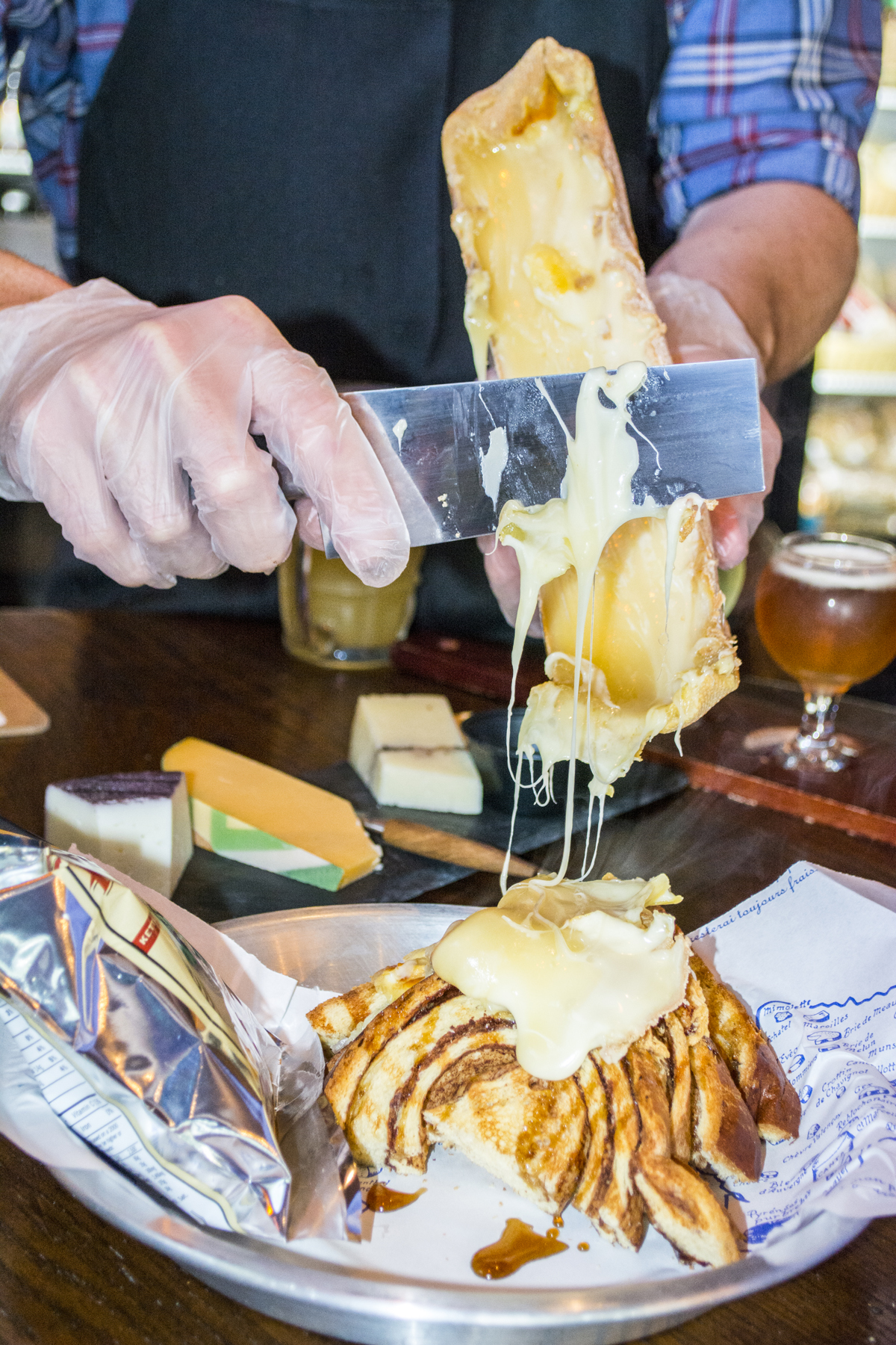   Brew Cheese owner David Striffler scrapes melted raclette cheese onto the French Toast Sandwich ($10)   Long Islander News photos/Barbara Fiore  