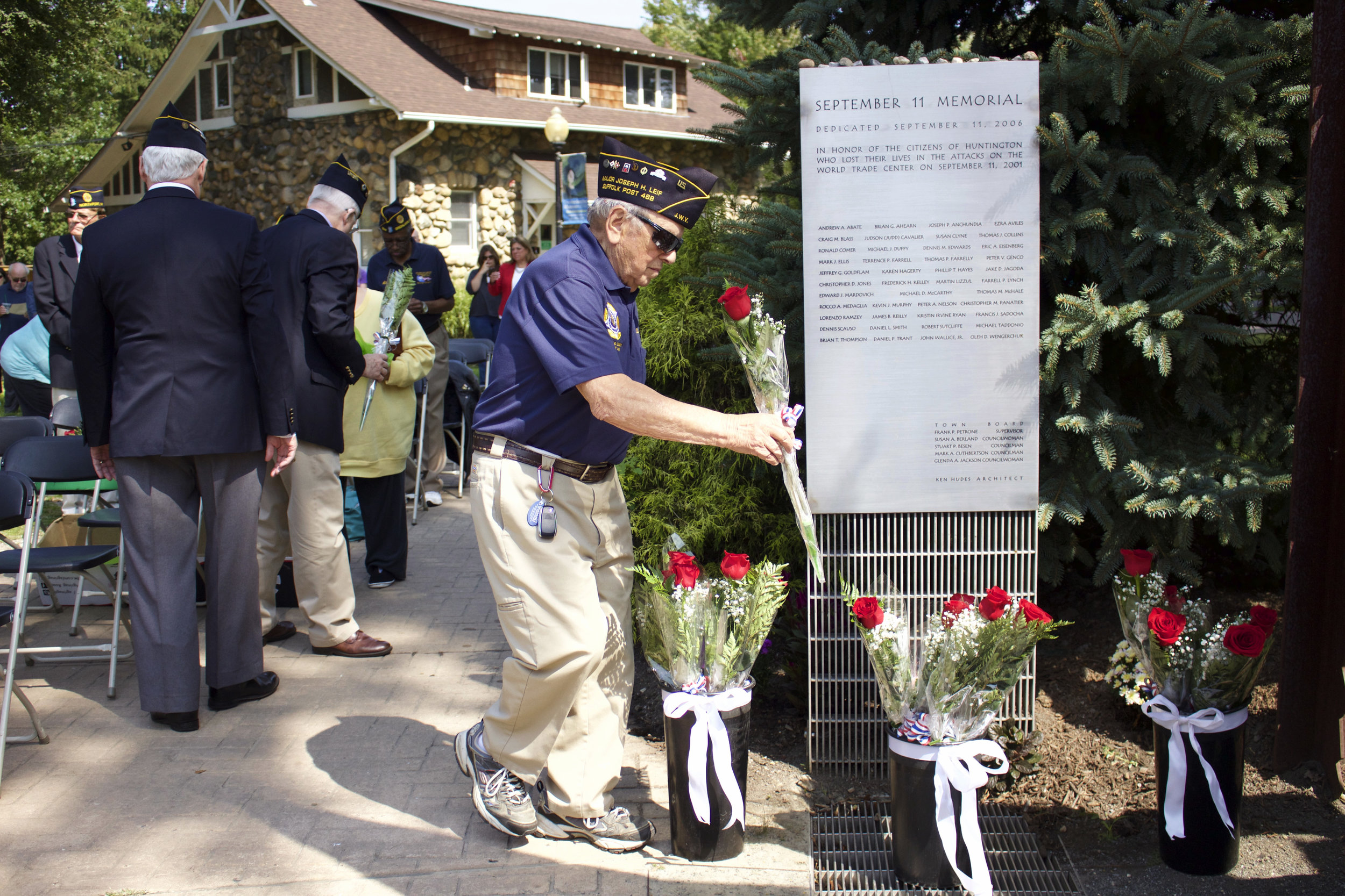   Major Joseph Leif, member of the Veterans Advisory Board, places roses in front of Heckscher Park’s 9/11 Memorial walkway during the reading of names.   Long Islander News photos/Janee Law  