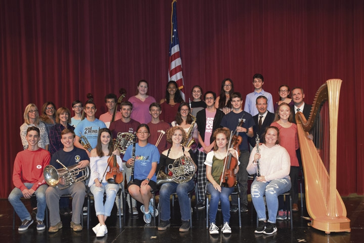 Northport High School NYSSMA All-State students with symphonic winds teacher Lynn Cromeyn, orchestra teacher Margaret Janke and Choral Teacher, Ellen McCarthy (back row, from left), Principal Daniel Danbusky and Director of Fine and Performing Arts Dr. Izzet Mergen (at right, next to harp). Photo Courtesy/Northport-East Northport School District