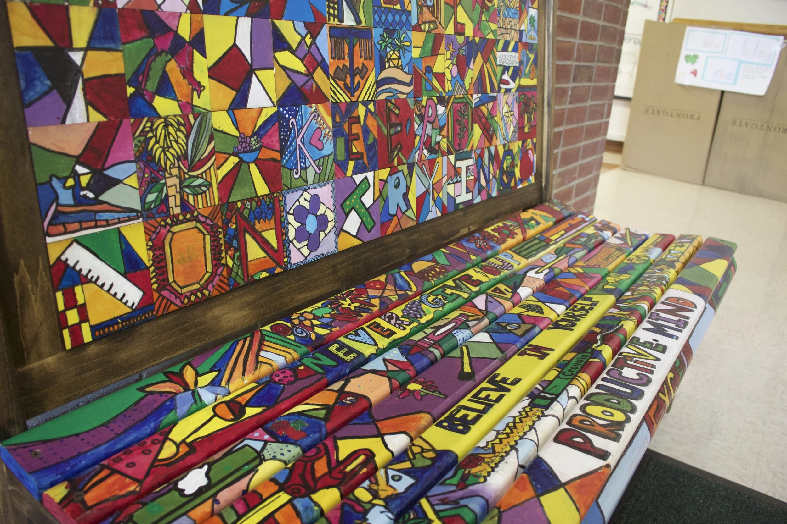 This colorful Romero Britto-inspired bench was installed at West Side School as a way to remind students to show kindness and represent grit. Long Islander News Photo/Janee Law