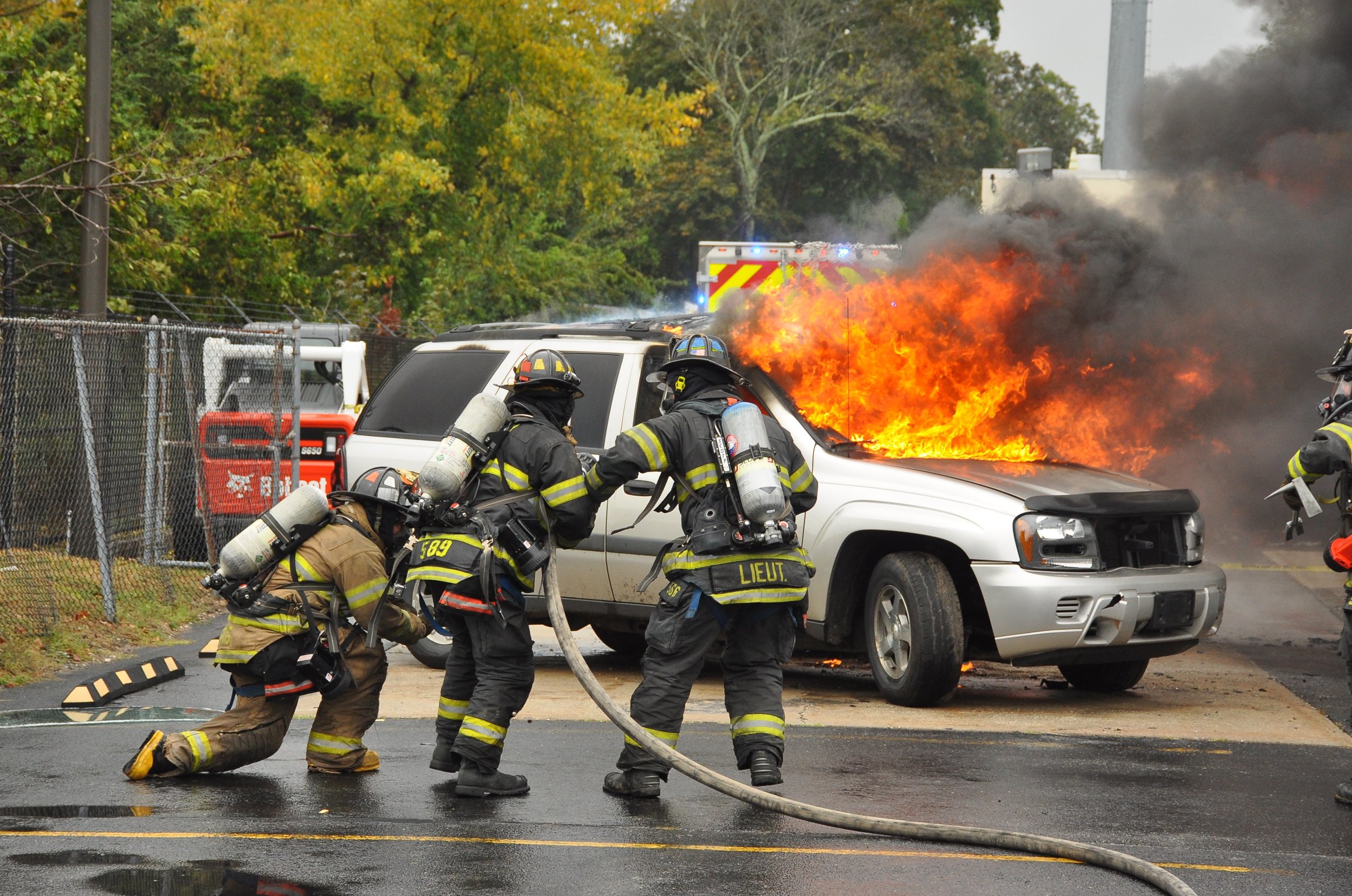   Melville firefighters demonstrate the process of extinguishing a car fire to those who attended its annual open house.   Photo by Steve Silverman  