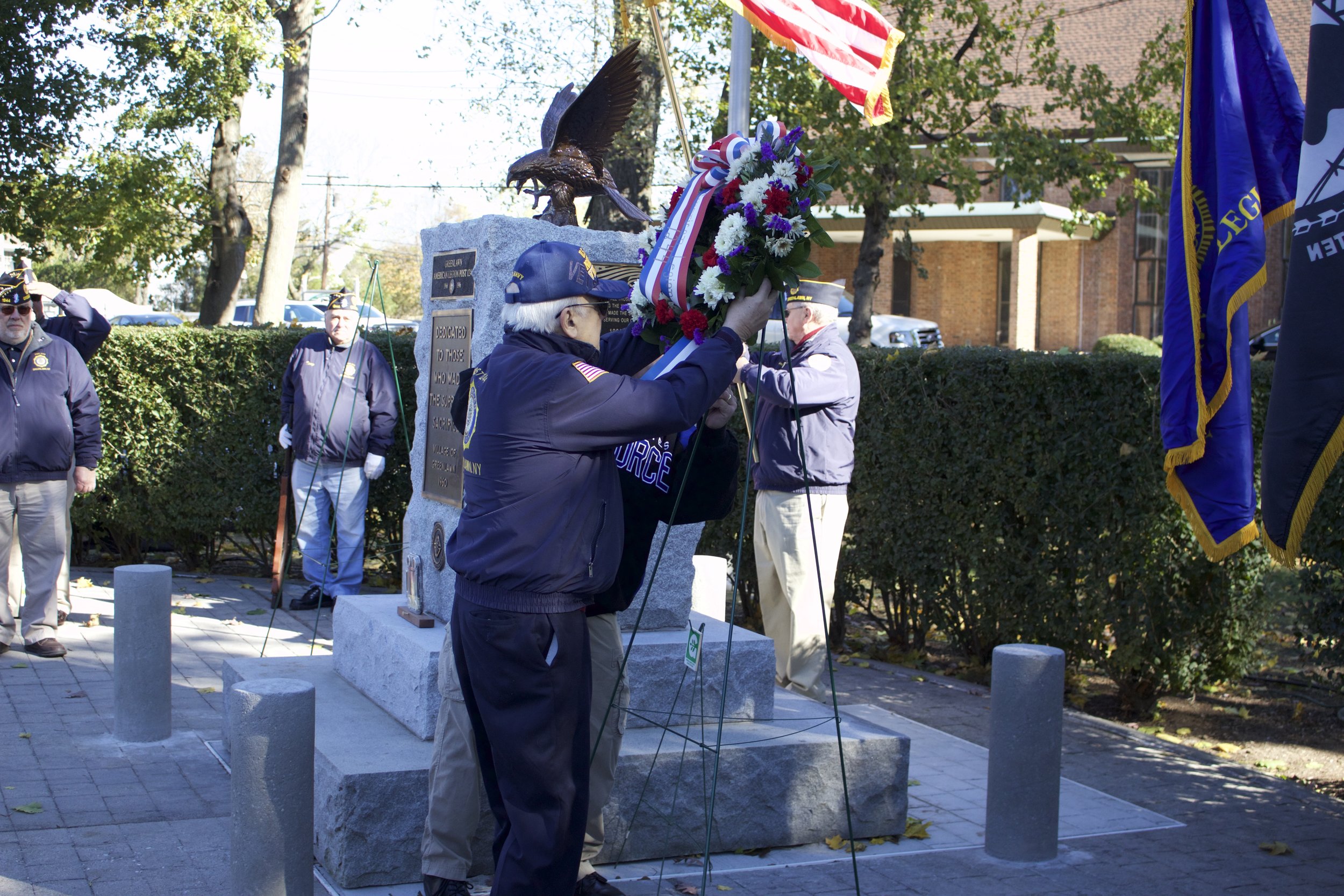 One American Legion Greenlawn Post 1244 member places a wreath at the monument during Saturday’s ceremony . Long Islander News Photo/Janee Law