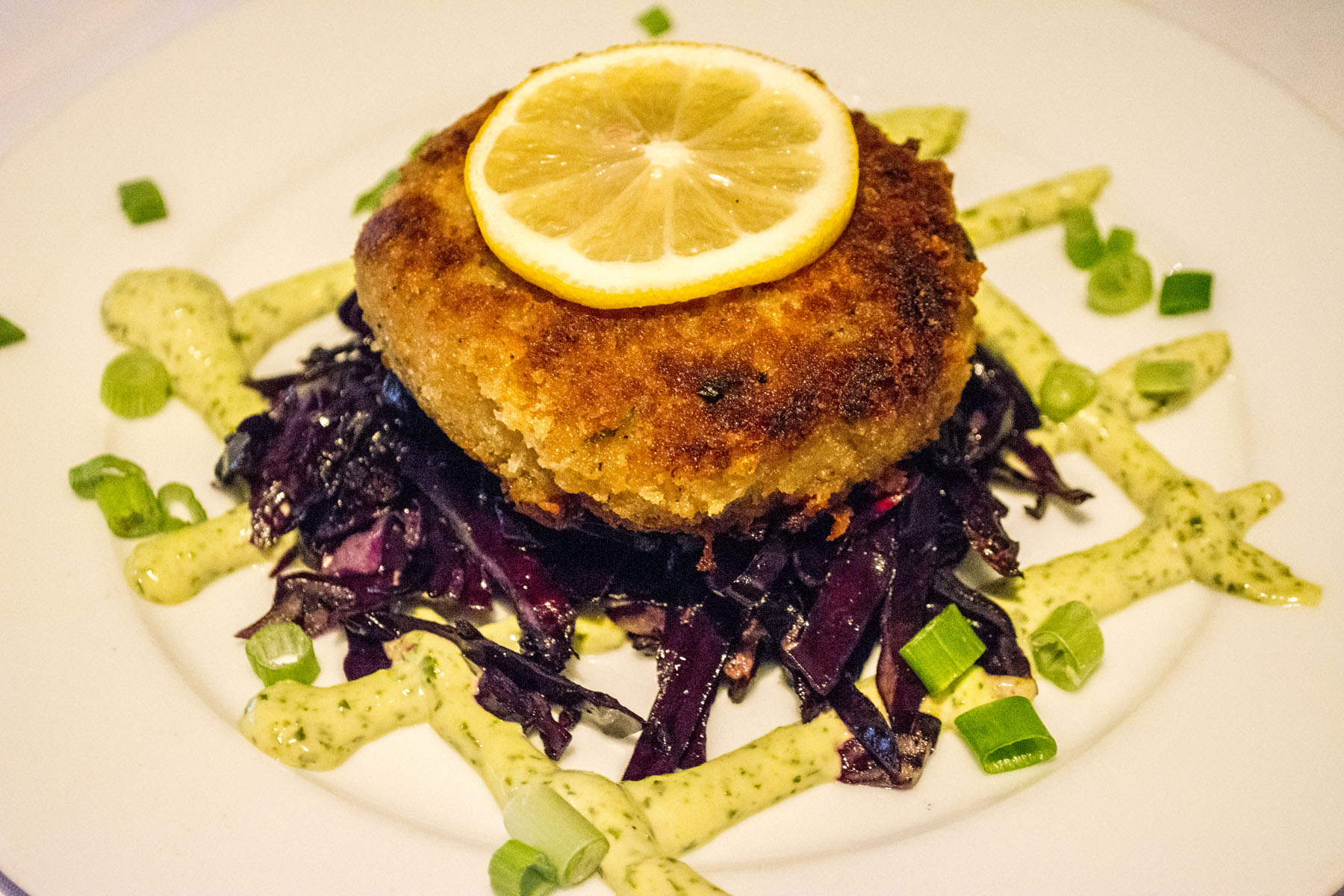   The Torta de Cangrejo ($13) is a jumbo lump crab cake tossed in panko breadcrumbs and served with basil aioli and sautéed red cabbage.   Long Islander News photos/Connor Beach  