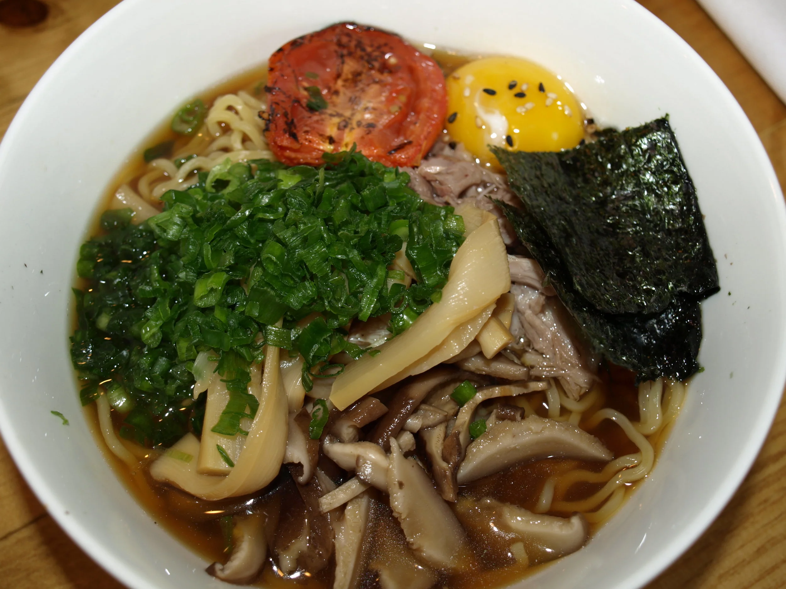  Shoyu Ramen ($13), above, brings together duck confit, menma, scallion, nori seaweed, oven roasted tomato, egg yolk and a wavy noodle. 