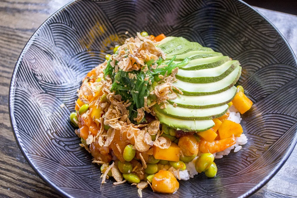   T.O.A.’s Special Poke Bowl ($12.95) features salmon, tuna, shrimp, scallops, seaweed salad, mango, onion crisps, edamame, avocado and sriracha aioli.  