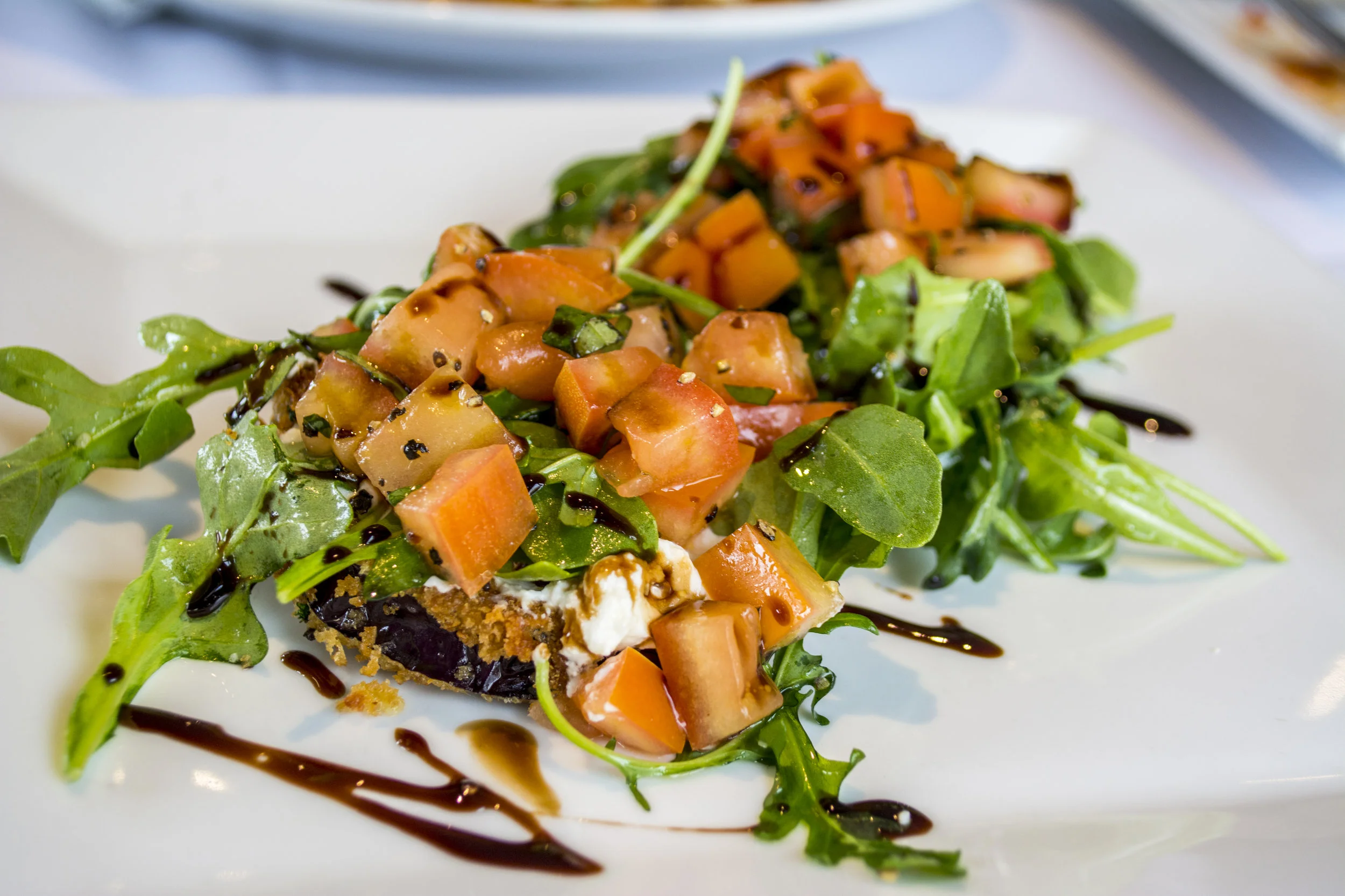   Eggplant Bruschetta topped with fresh ricotta and truffle infused baby arugula.  