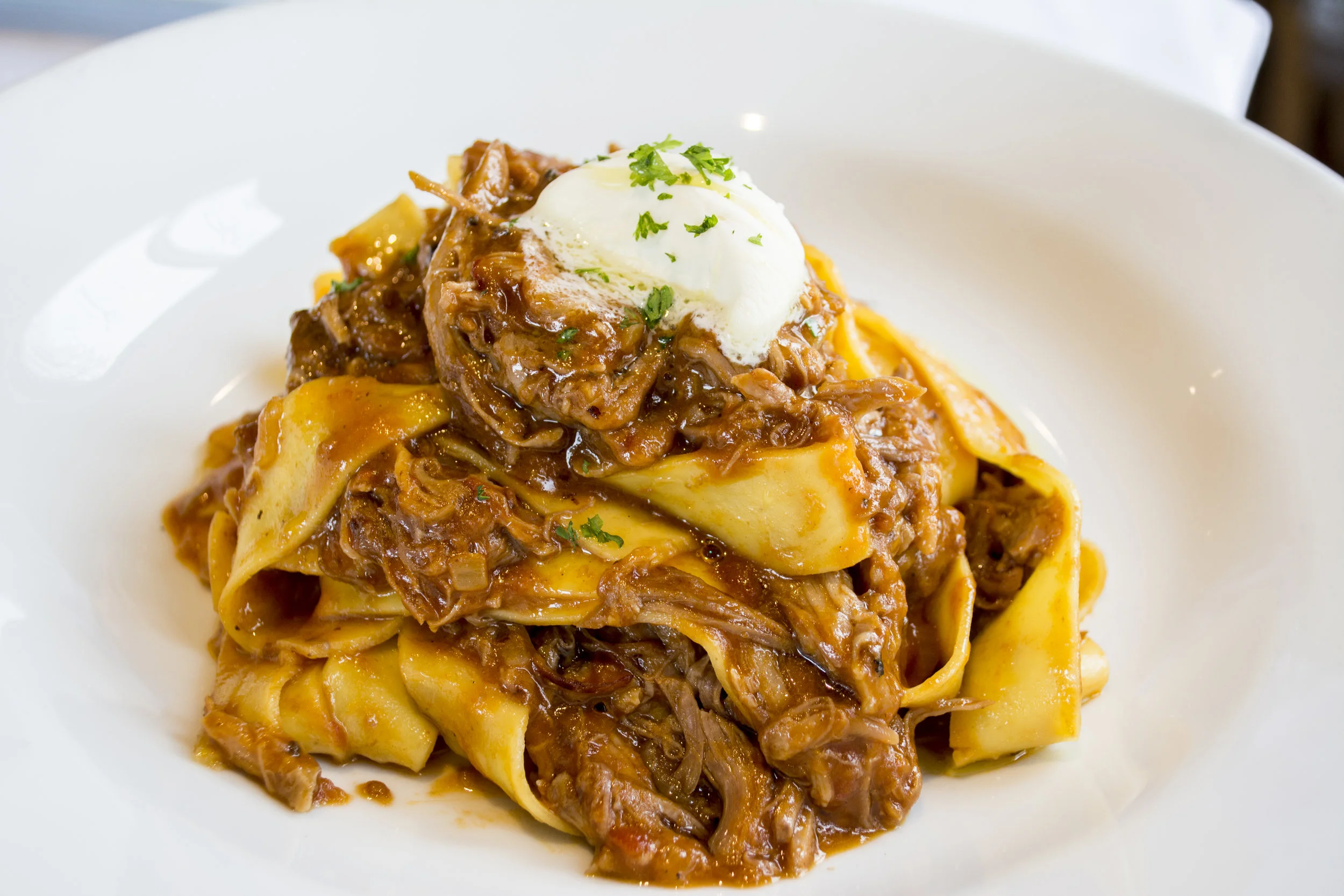   Pasta Pappardelle, served with pork shank osso bucco ragu and topped with mascarpone cream.  