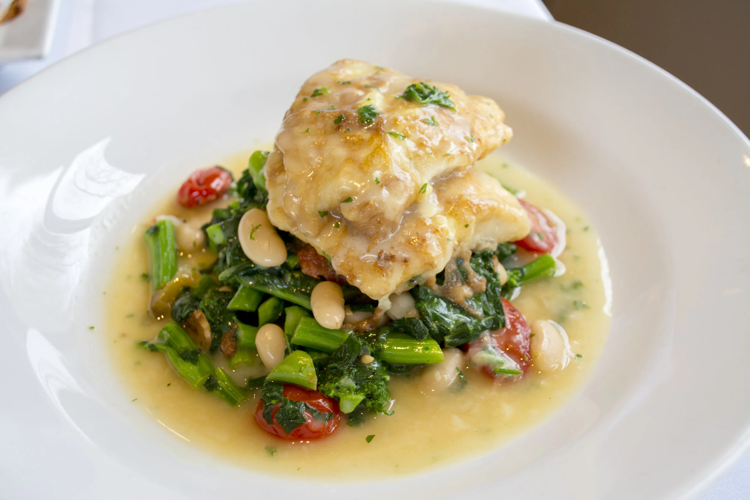   Red Snapper Francaise served over broccoli rabe, white beans and cherry tomatoes in a lemon butter sauce.  