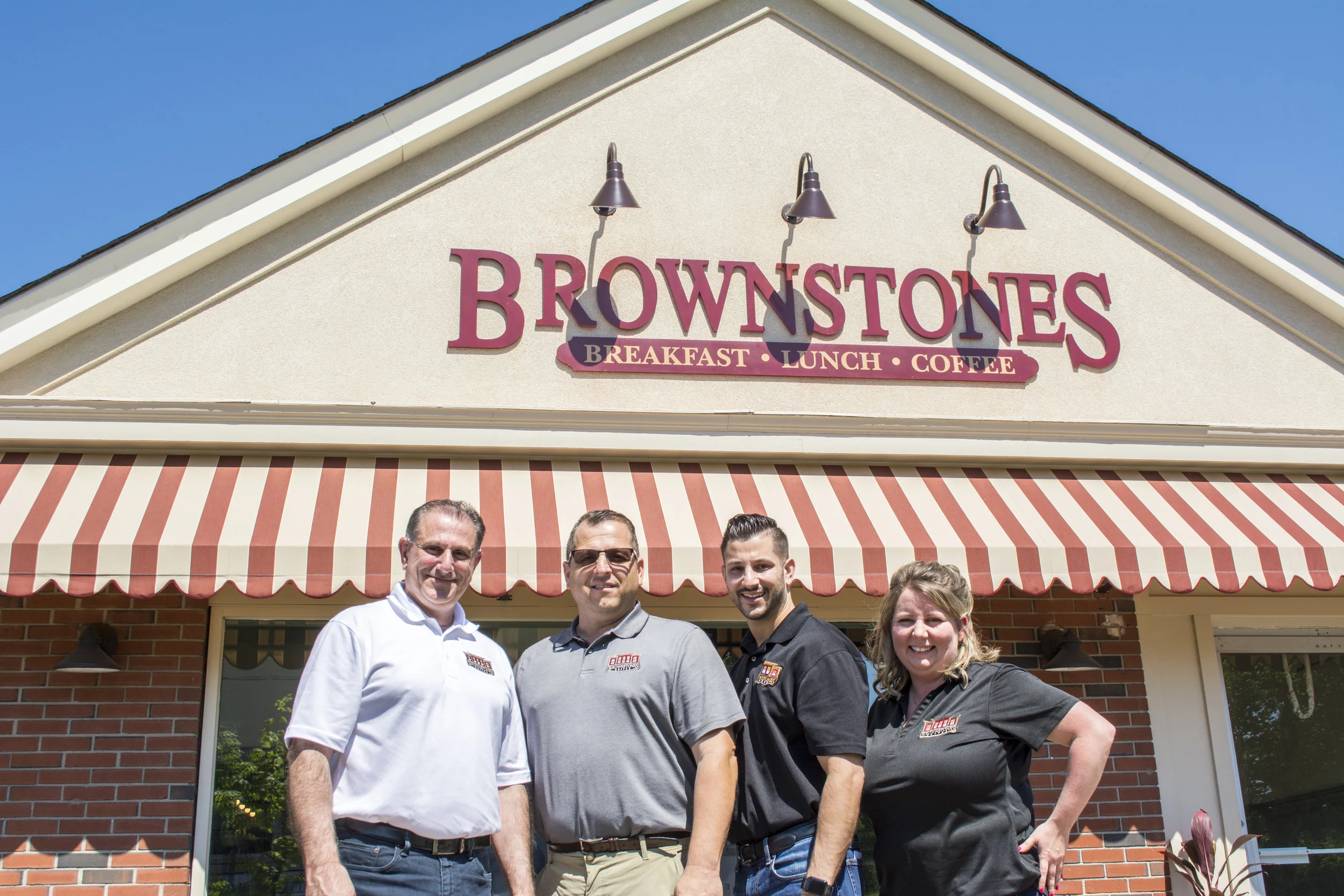   Brownstones partners, from left: Manny Kourounis, John Mangino, Chris Kourounis and Christina Walberg stand outside the local chain’s newest location in East Northport.   (Long Islander News photos/Connor Beach)  
