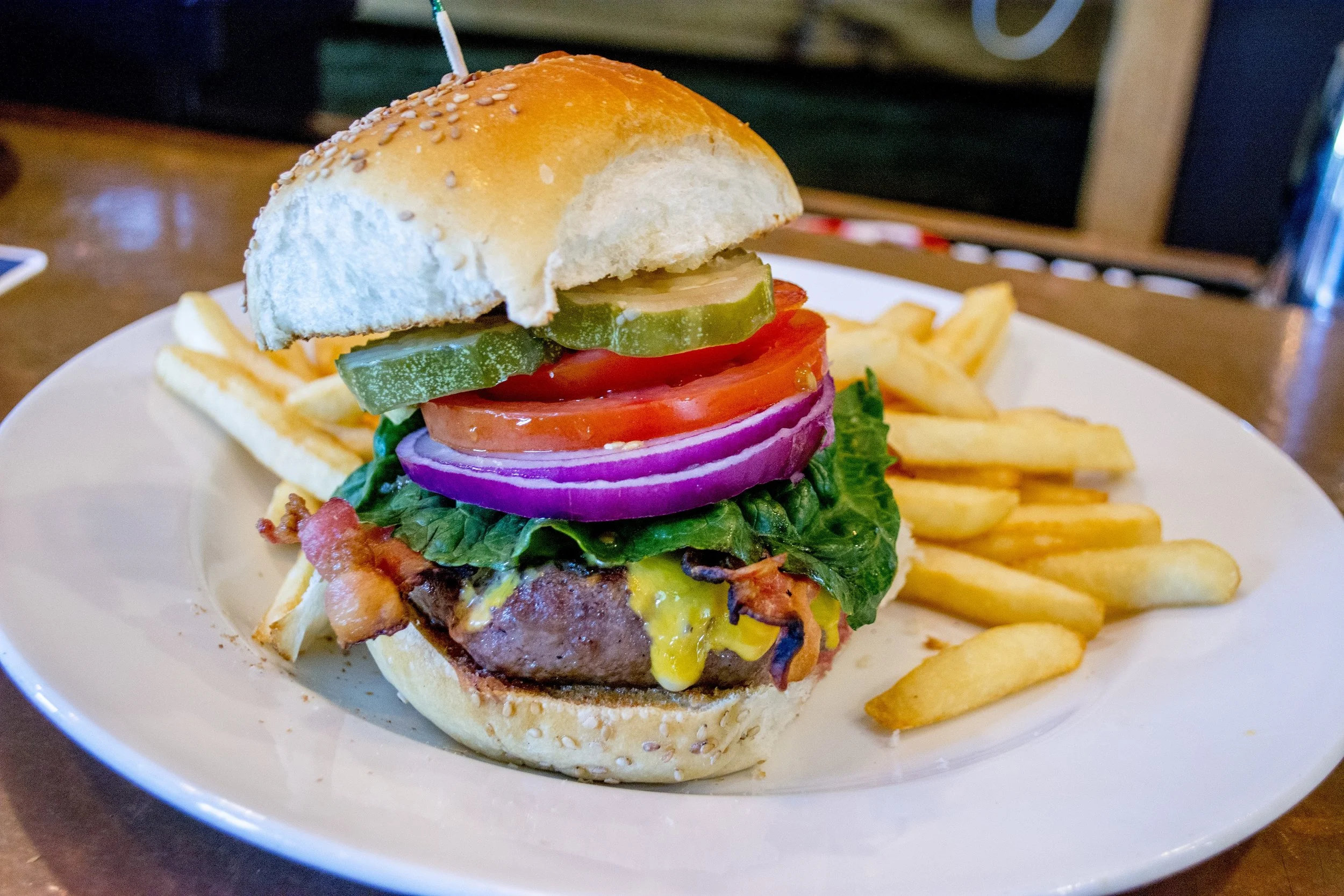   Classic Burger ($15) is topped with American cheese, bacon, lettuce, tomato, onion and pickles  