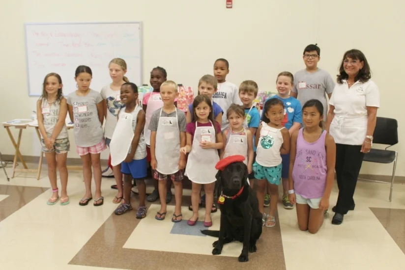  The DogVinci workshop participants with “global sensation” Dagger, front, and his adoptive owner Yvonne, right.  