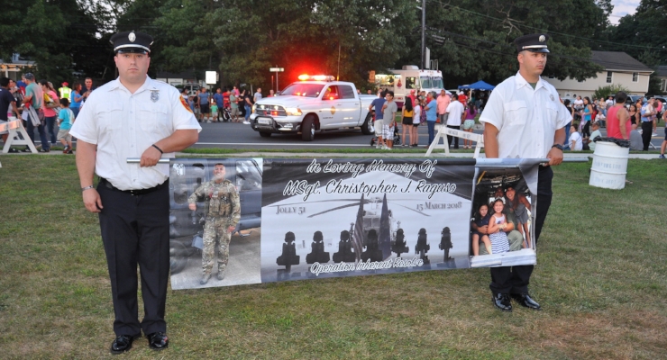   Members of the Commack Fire Department carry a banner in memory of Master Sgt. and Honorary Chief Christopher Raguso, who was killed earlier this year in a helicopter crash in Iraq.  