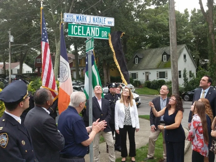 Mayra Natale unveils a street sign dedicating Iceland Drive to honoring the memory of her late husband, Mark.