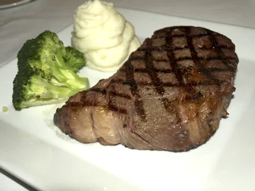  Rib Eye Steak is served simply — with mashed potatoes and broccoli. 