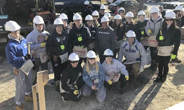 Habitat for Humanity of Suffolk executive director and John Glenn alumnus Tracey Edwards joins Glenn students who were helping to raise the walls of a Habitat for Humanity home on March 13. Photo courtesy Habitat for Humanity