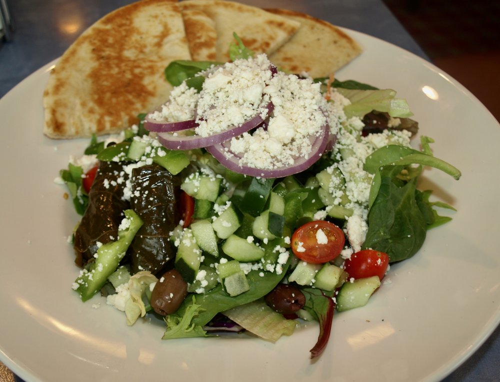  Greek salad with feta, grape tomatoes, cucumber, red onion, peppers, black olives and grape leaves. 