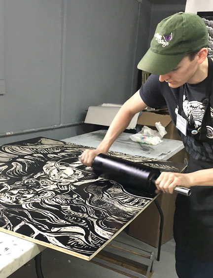   Big Ink’s Lyell Castonguay inks a woodblock in preparation for running it through the press.  