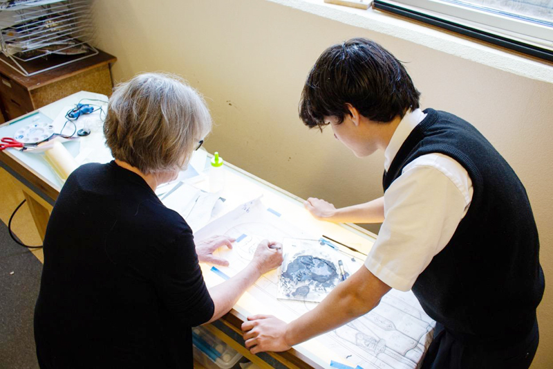 Art teacher Jennifer Baldwin-Schafer and student Matthew Meberg work on the stained glass design. Each of the 39 custom windows pays tribute to the school’s patron families.