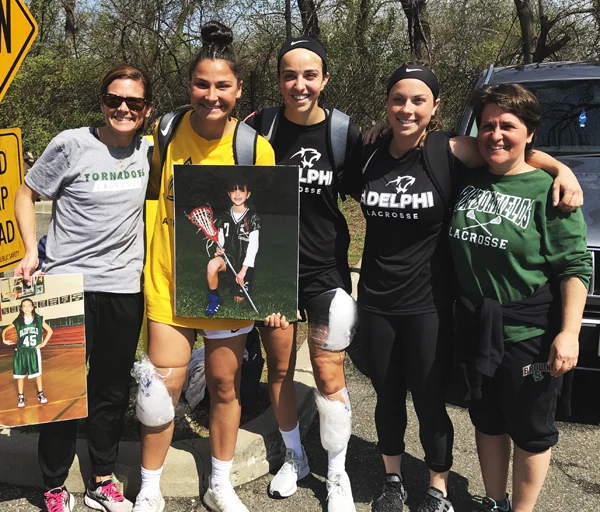The three Harborfields players who helped Adelphi’s Lady Panthers to an NCAA Div. II title with their former high school coaches on “Senior Day” back in April. From left are Coach Kerri McGinty, Gianna Bifulco, Chelsea Abreu, Kailey Broderick, and Coach Mary Santomauro.