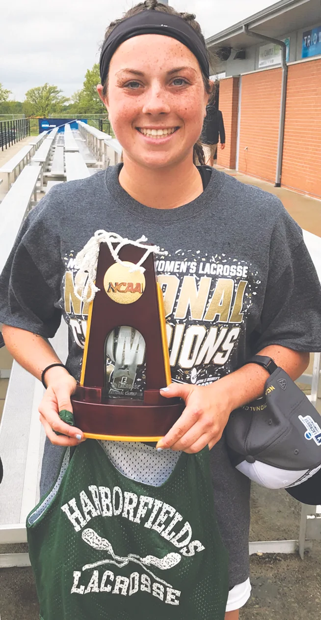 Kailey Broderick pairs her old Harborfields travel jersey with her new NCAA Div. II championship trophy.