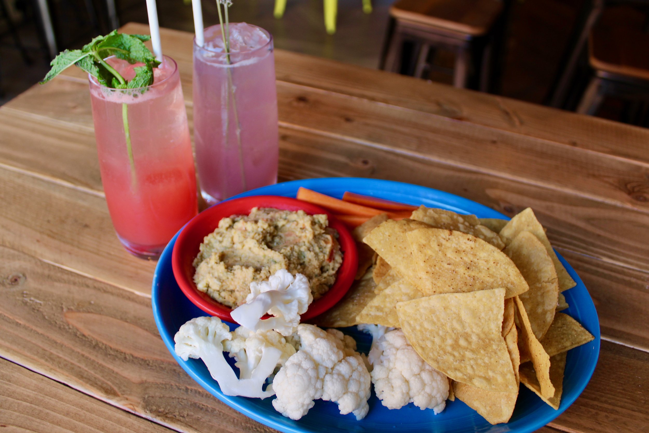 Habanero Pumpkin Seed Hummus with crudite and chips, alongside the Mariposa and Breath and Stop cocktails.