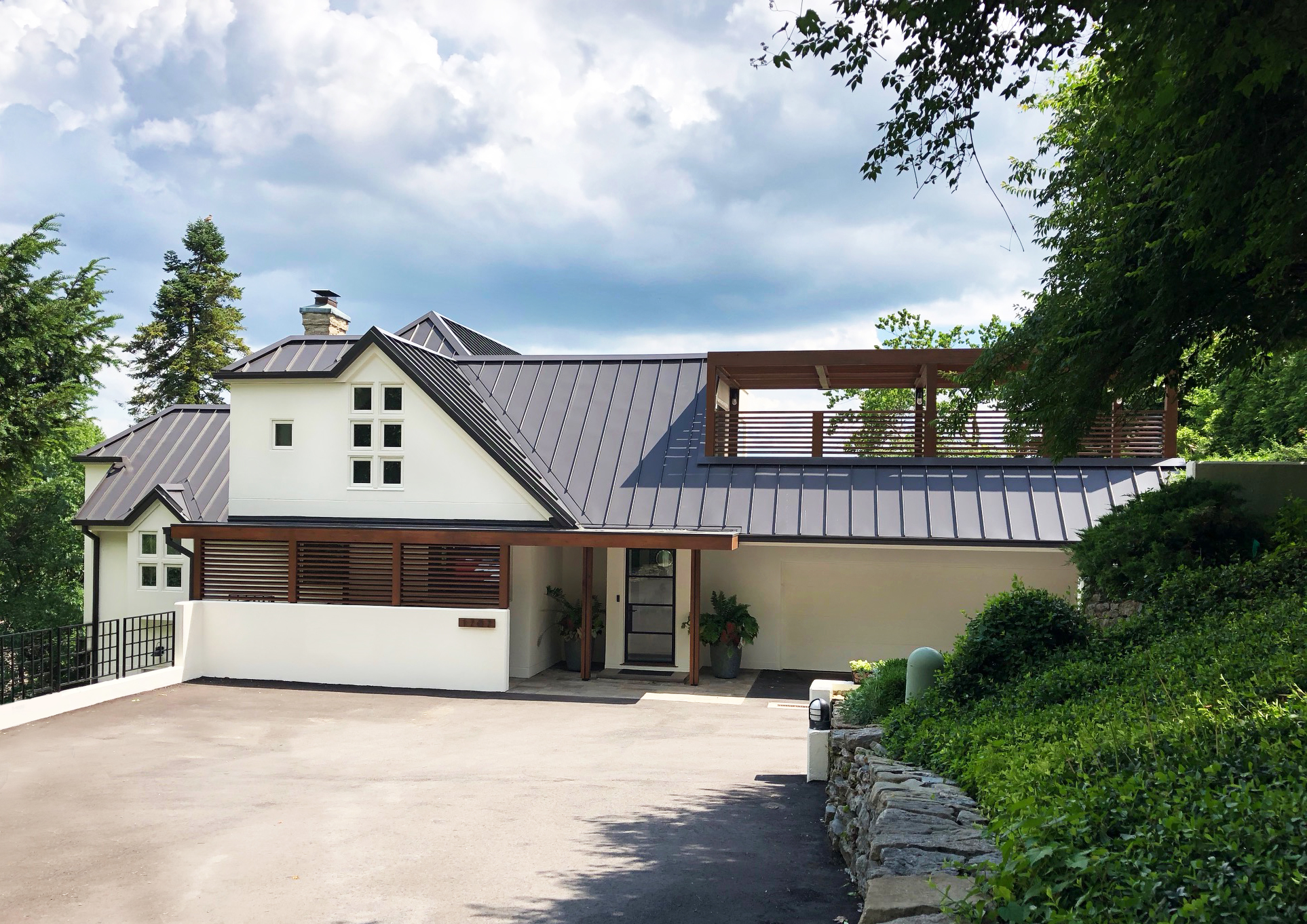 Post Modern Renovation This private residence is located in East Walnut Hills, Cincinnati. The purpose of this renovation was to create cohesion and simplicity—updates include a new standing seam metal roof and a covered cedar slat entry and pergola. These additions created more functional shaded indoor and outdoor spaces. Construction by: The English Contractor