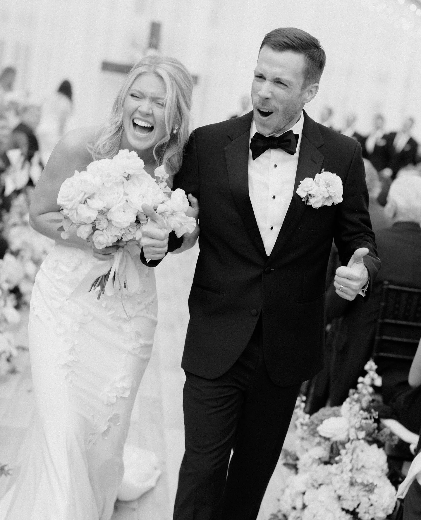 A bride and groom laughing together, in black and white