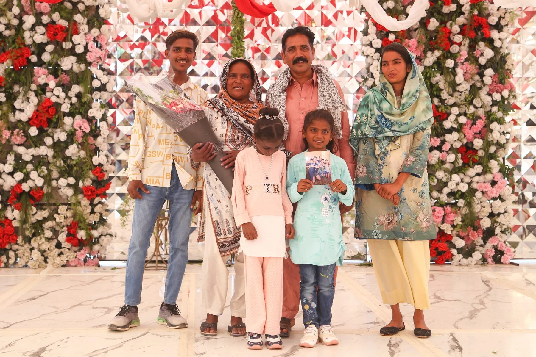 Javed Sher Masih and family at their Freedom Celebration, holding Grant’s family photo