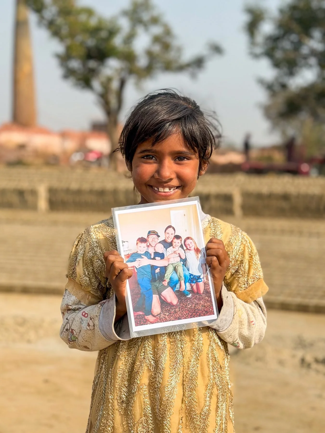 Girl from Yousaf Sohan’s family holding Grant’s family photo