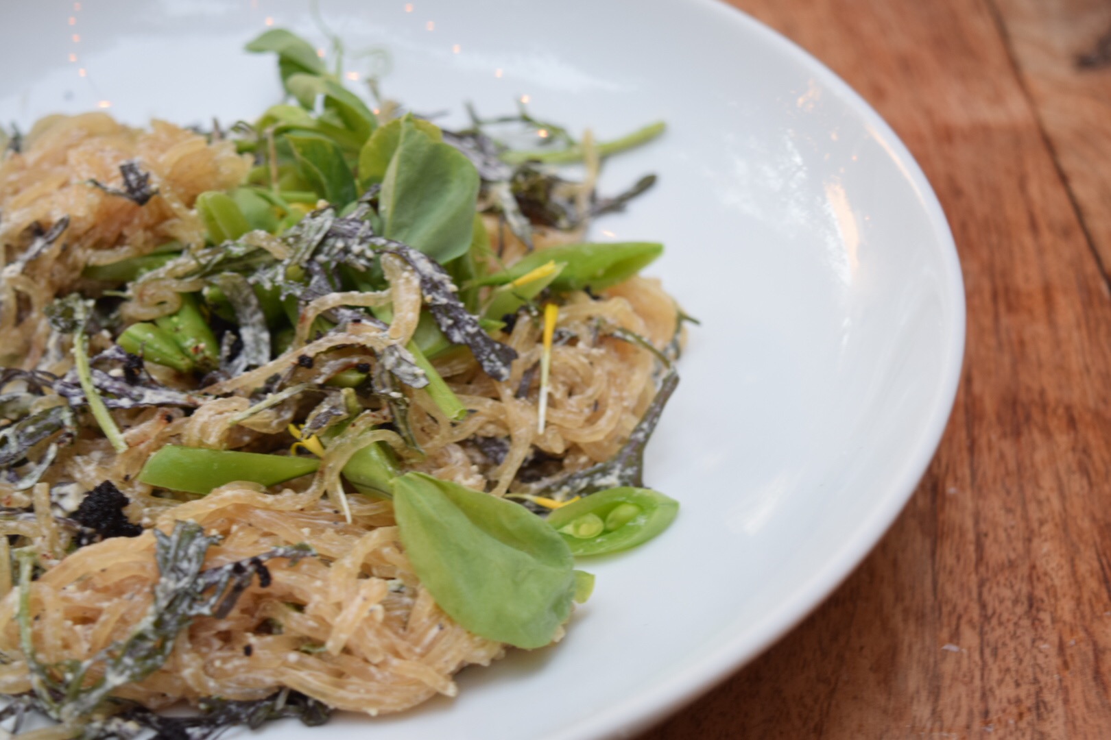 Black pepper Kelp Noodles. Snap Peas. Spicy Greens. Dehydrated Olives. 