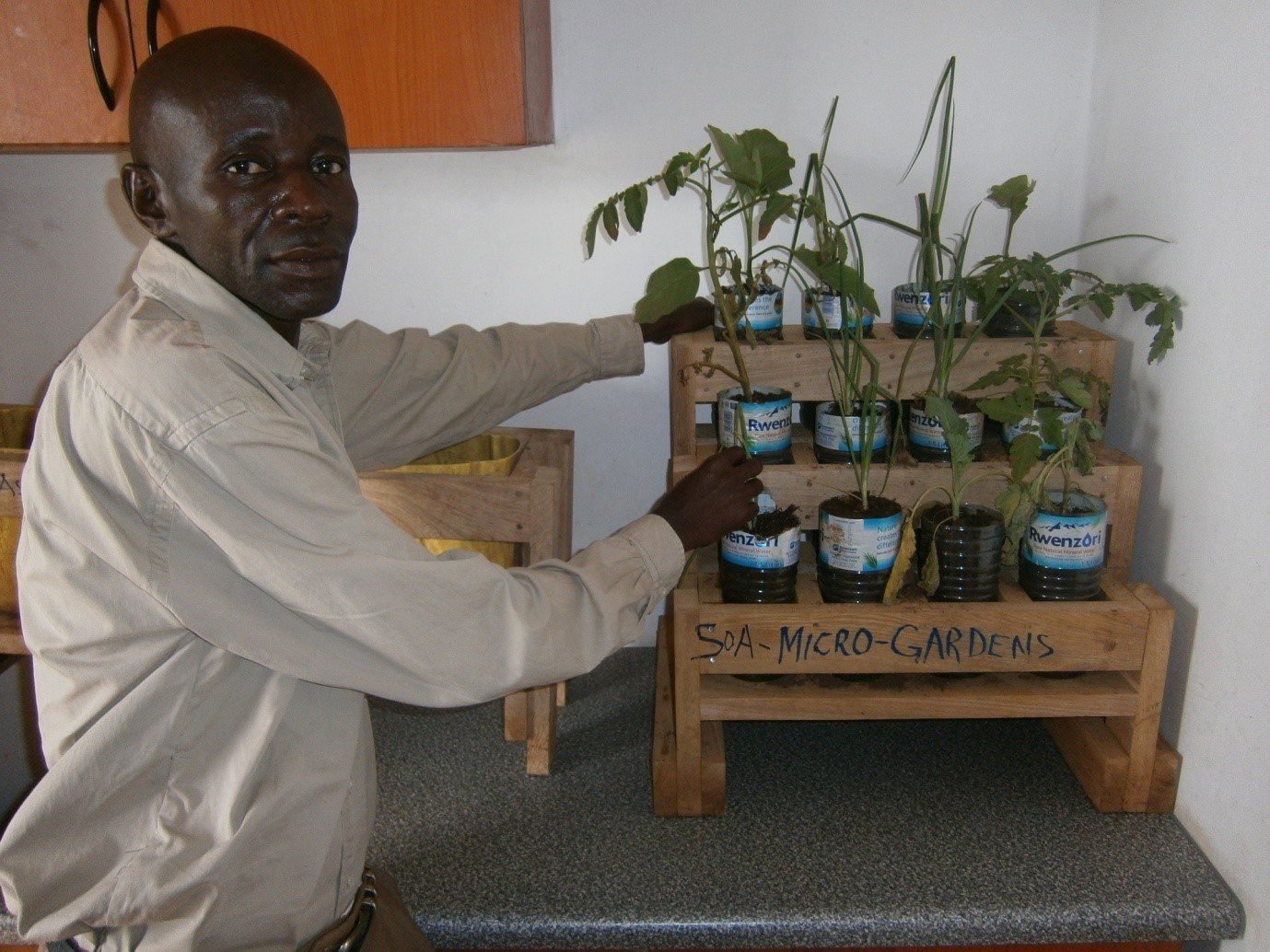 Bosco, one of the CHPs in Bukasakya, displaying micro garden. We are able to grow onions, carrots, beets and other veg