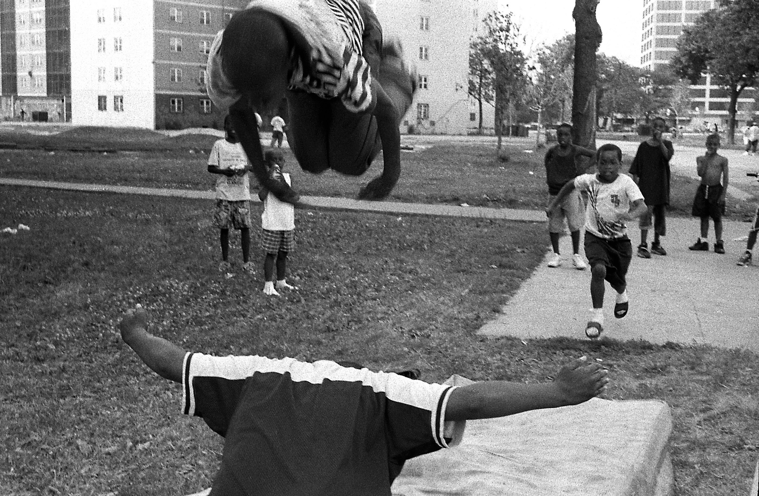 Children at Stateway compete with one another, doing flips on to a discarded mattress. PHOTO BY PATRICIA EVANS 
