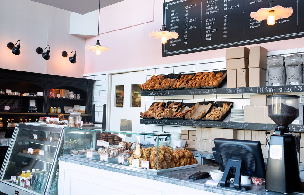 a bakery storefront counter with pastries in their cases