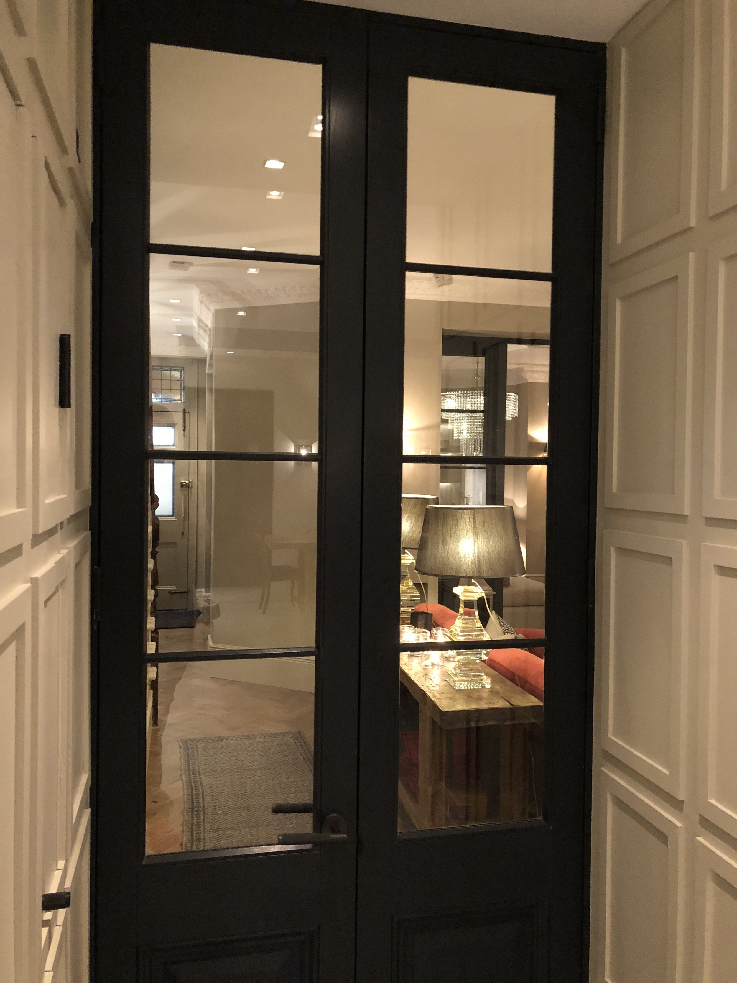 Elegant hardwood timber doors provide practical means of separation between living areas in the ground floor. The tall dark grey french doors provide continuity of design through the ground floor.