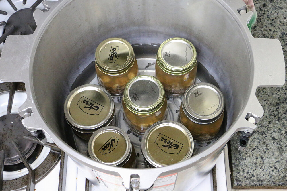 Closed mason jars with beans in pressure cooker